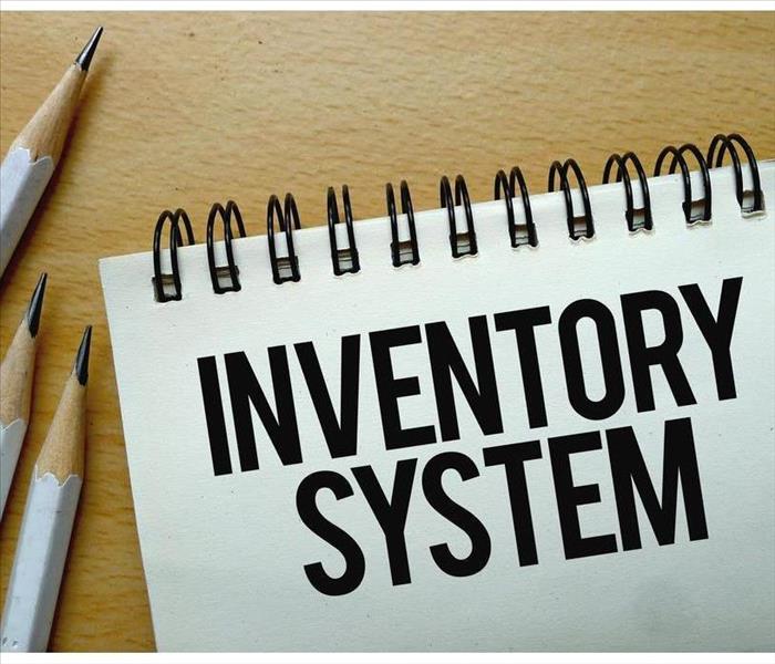 Three pencils and notebook that says Inventory System
